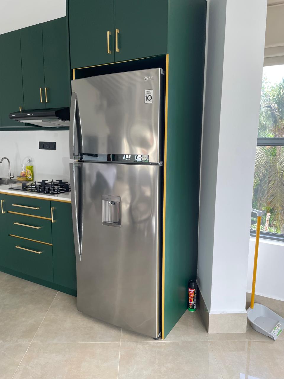 Kitchen with water-dispenser fridge freezer beside the balcony window